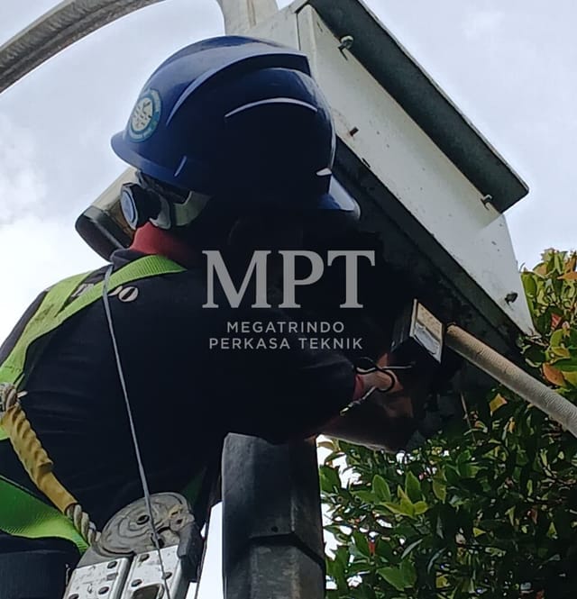Technician servicing a CCTV camera enclosure at height