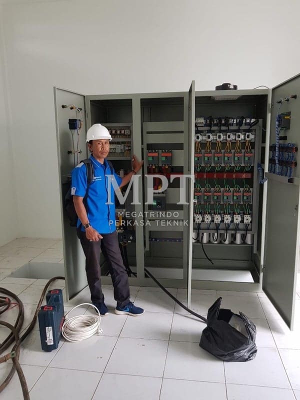 A Megatrindo technician beside a power panel during installation